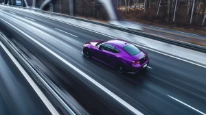 Ljubičasti auto brzo vozi na autocesti